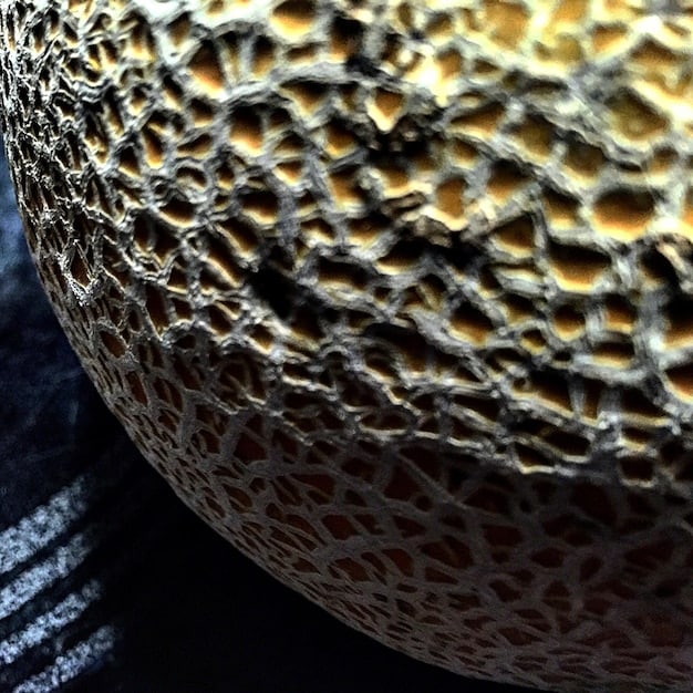 A macro photograph showcasing the surface texture and intricate detailing of a limited-edition 2025 Shonen Jump anime figure. The focus is on the figure's facial features, highlighting the precision of the paint job and the quality of the sculpting.