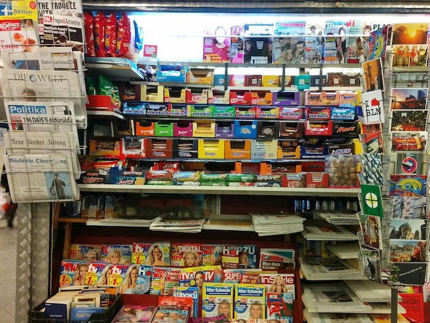 A shelf displaying outdated anime merchandise, including generic keychains and low-quality posters, covered in dust in a store.