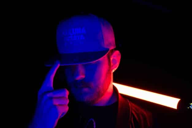 A close-up of a cosplayer attaching LED strip lights to the interior of a helmet using adhesive. The cosplayer is carefully positioning the lights to ensure even distribution and maximum brightness inside the helmet.