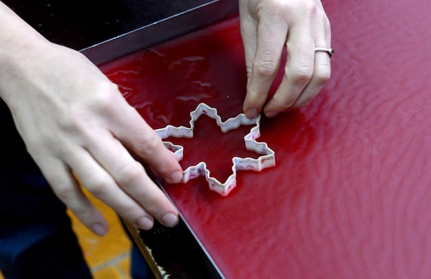 A cosplayer carefully using a heat gun to mold a sheet of thermoplastic around a custom-made mold form. The workspace is well-lit and organized, with various tools and safety gear visible in the background.