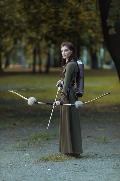 A cosplay photograph capturing a cosplayer dressed as a warrior mid-jump, wielding a prop sword. The background is blurred to accentuate the motion.