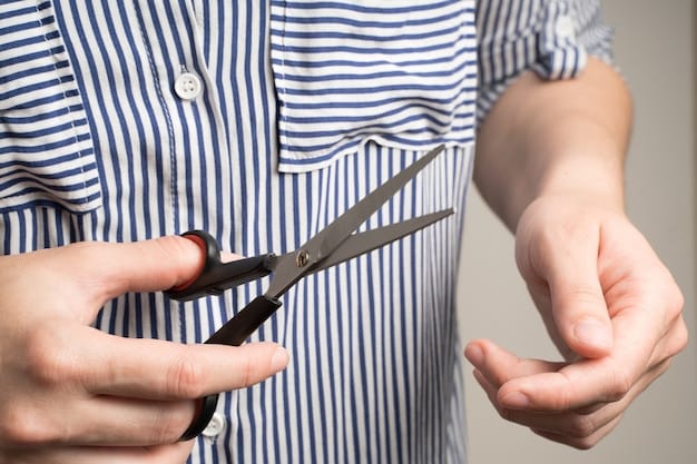 A close-up shot of someone using thinning shears to carefully trim the ends of a bright blue wig, reducing bulk and creating a more natural-looking edge. The wig is on a stand, and the background is a well-lit craft room.