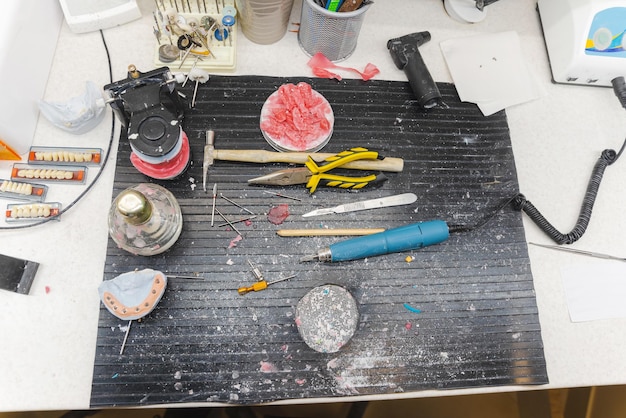 A well-organized cosplay crafting station with close-ups of craft foam sheets, a heat gun, various cutting tools, and finished Worbla armor pieces, illustrating the tools described in the section.