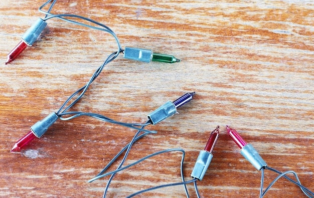 A close-up shot of various LED components laid out on a workbench. There are LED strips, individual LEDs, small breadboards, wires of different colors, resistors, and a small microcontroller. The LEDs are lit up in different colors, showcasing their functionality. The image highlights the complexity of choosing the right components for a cosplay LED project.